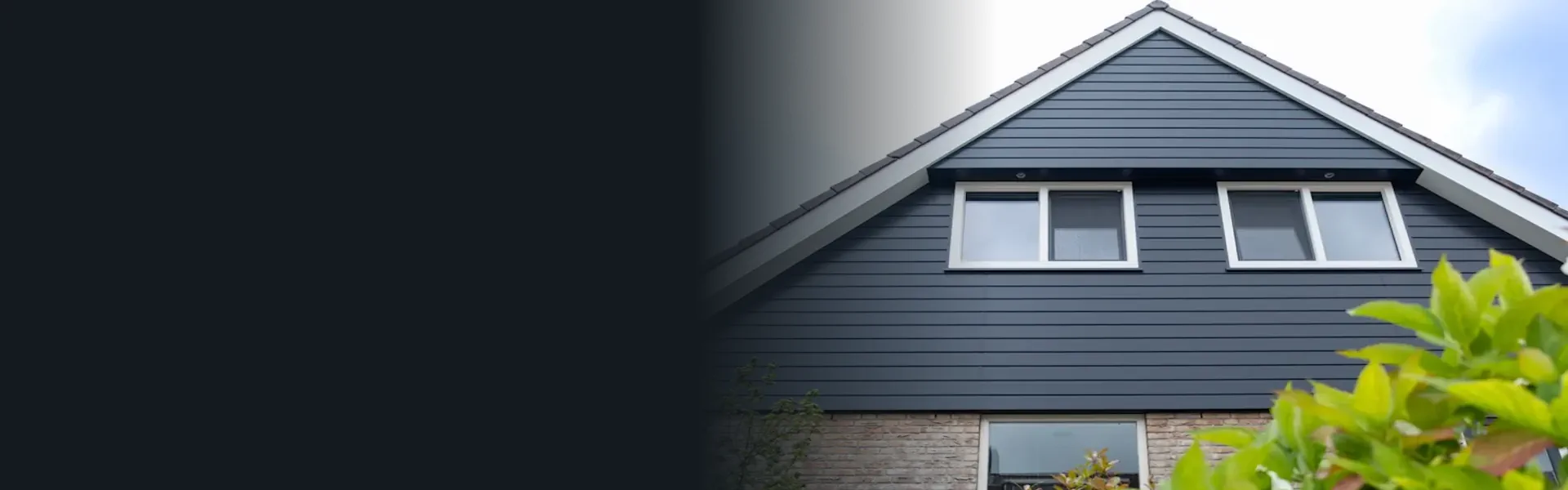 Woning met donkerblauwe Keralit gevelbekleding en witte kozijnen