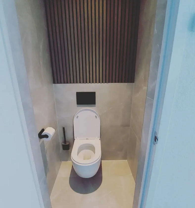 Wandtoilet in een betegelde toiletruimte met houten wandafwerking