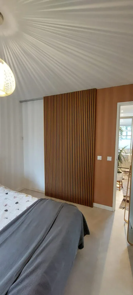 Maatwerk timmerwerk met een houten lattenwand in een slaapkamer