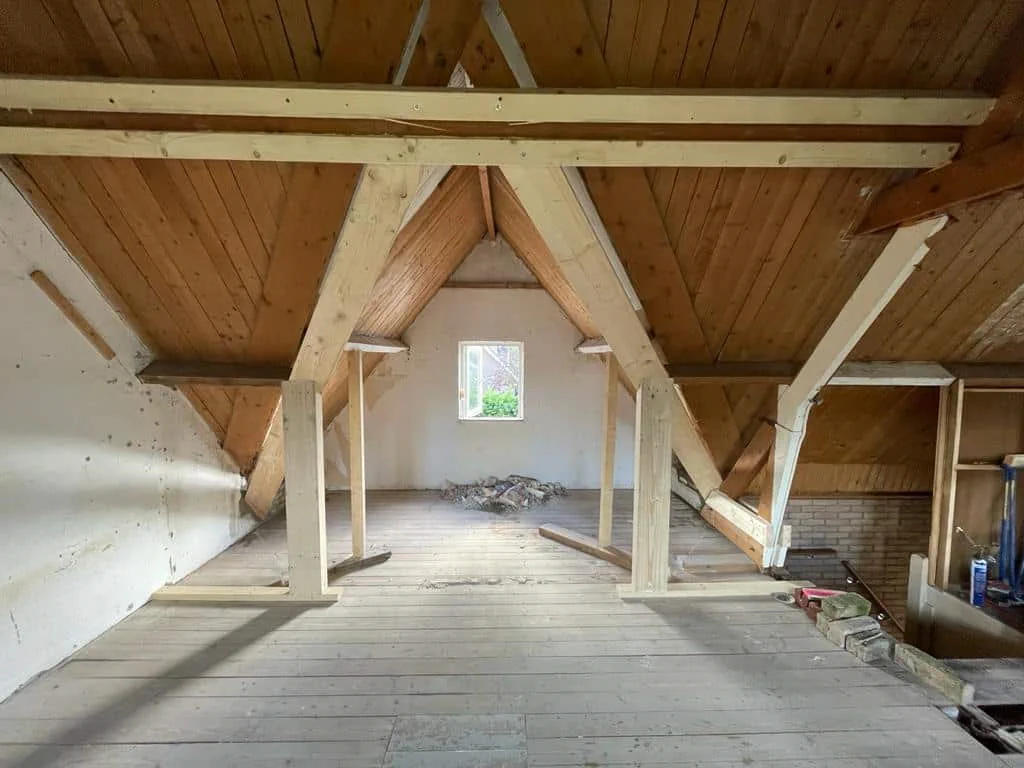 Timmerwerk aan een houten zolderconstructie met zichtbare draagbalken