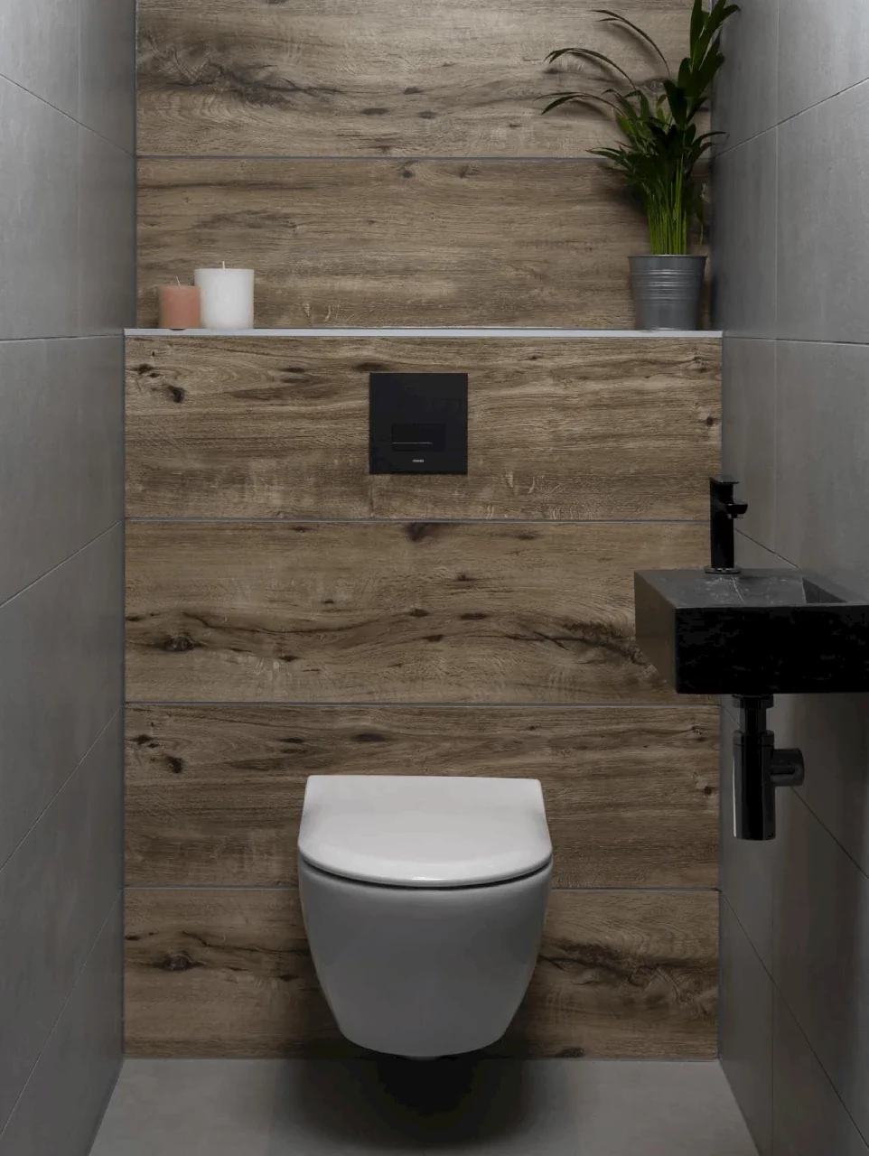 Wandtoilet met zwarte bedieningsplaat, wastafel en houtlook wandbekleding.