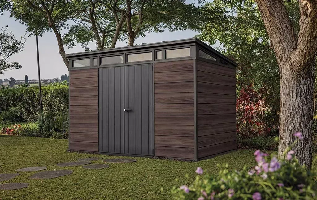 Tuinhuis op maat met dubbele deuren en hoge ramen in een groene tuin